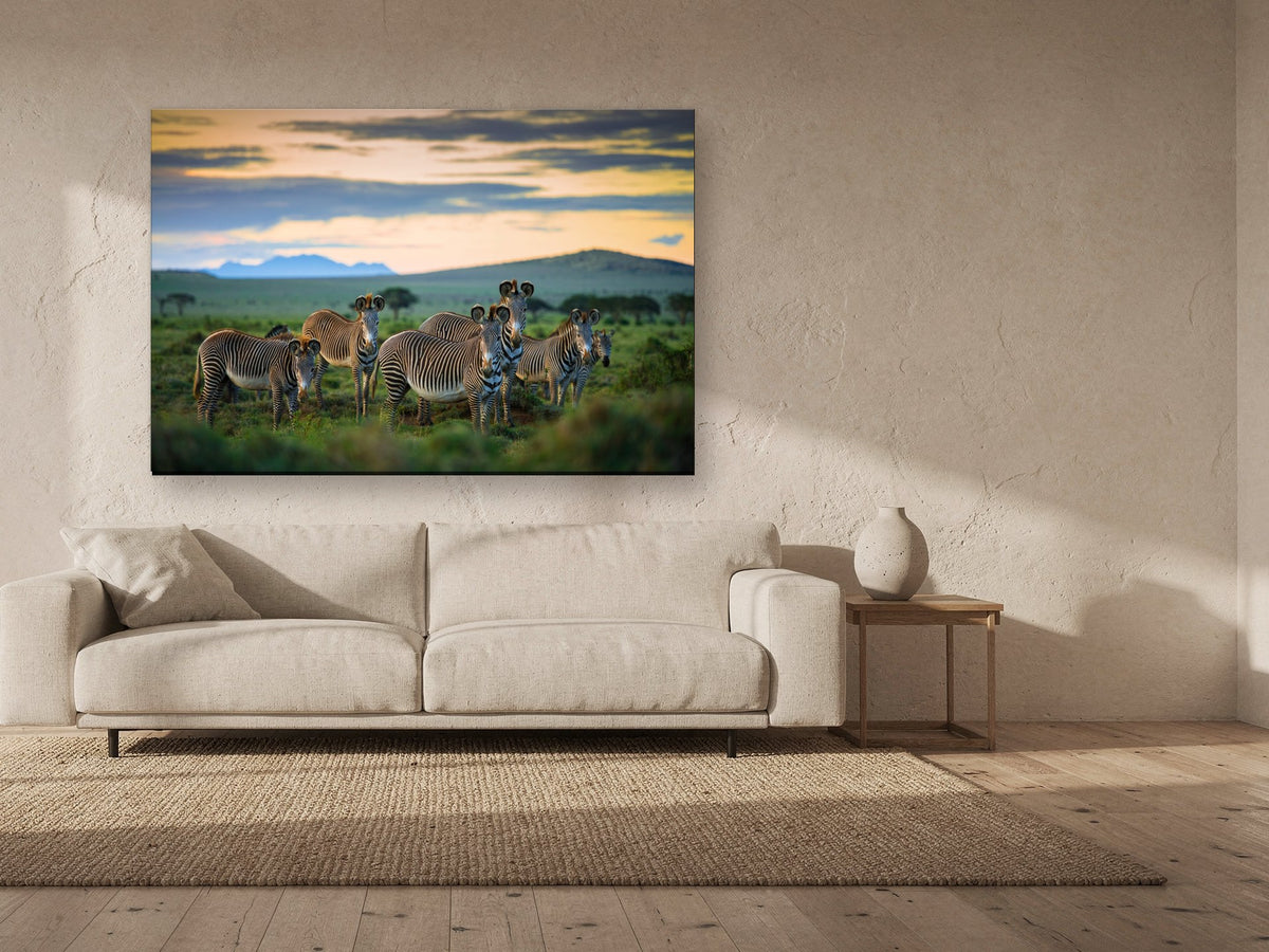 The Family by Shannon Wild, stretched canvas 60 x 40 in, above a sofa in a living room (desktop hero, canvas physics pass 2026-09-18)
